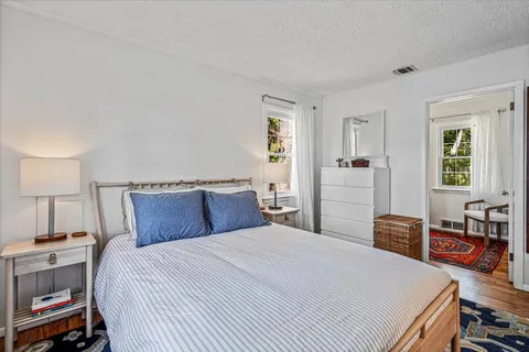 a bedroom with a bed and wooden floor