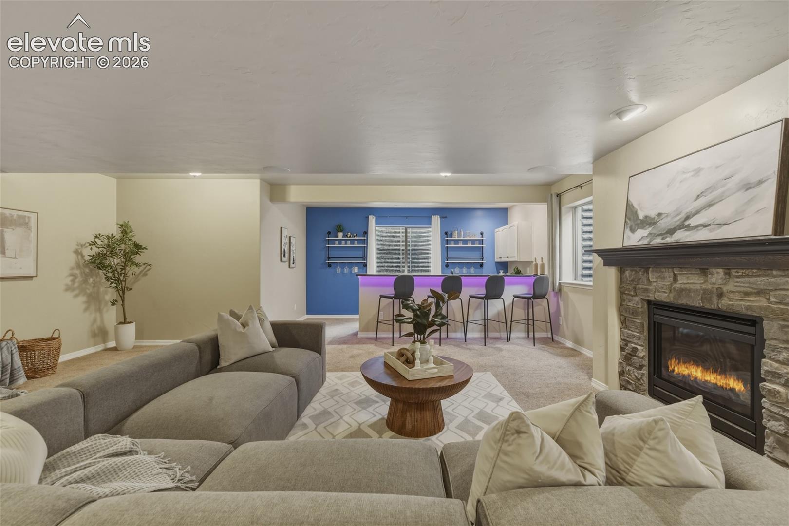 1118 Spectrum Loop Colorado Springs, CO 80921 - Photo 27 of 50 Stacked stone fireplace with a dark wood mantel, recessed lighting, and a built-in wet bar with shelving