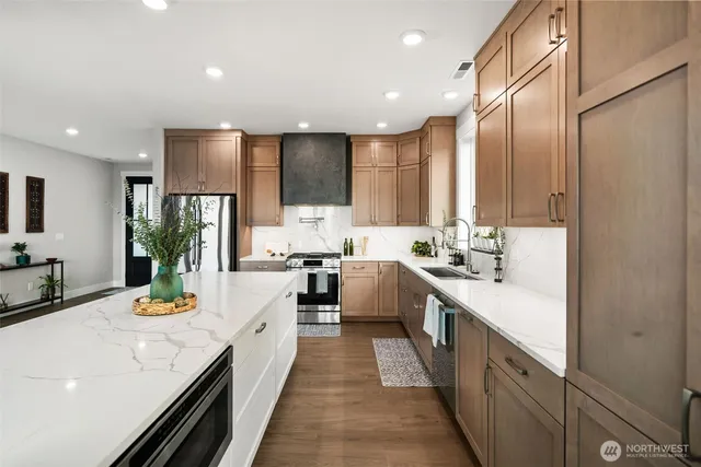 a large kitchen with stainless steel appliances lots of counter space and wooden floor