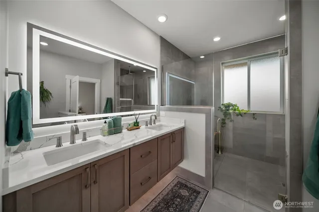 a bathroom with double vanity and a mirror