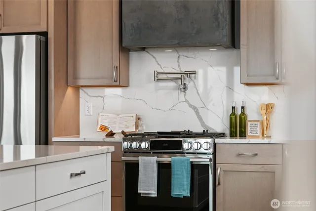 a kitchen with stainless steel appliances granite countertop a stove and a refrigerator
