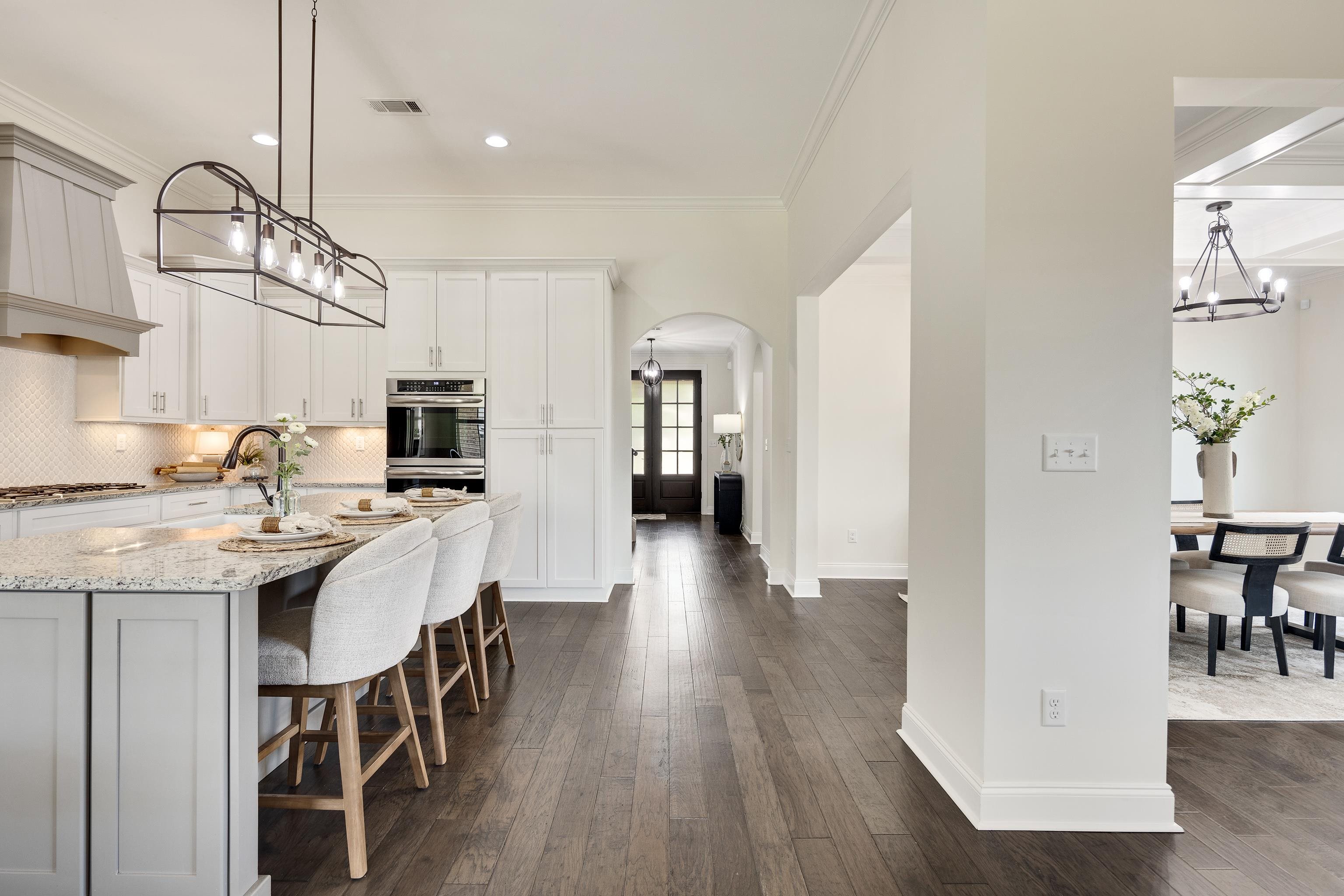 4728 Carousel Lane Collierville, TN 38017 - Photo 15 of 40 Kitchen featuring arched walkways, appliances with stainless steel finishes, light stone counters, decorative backsplash, and a chandelier