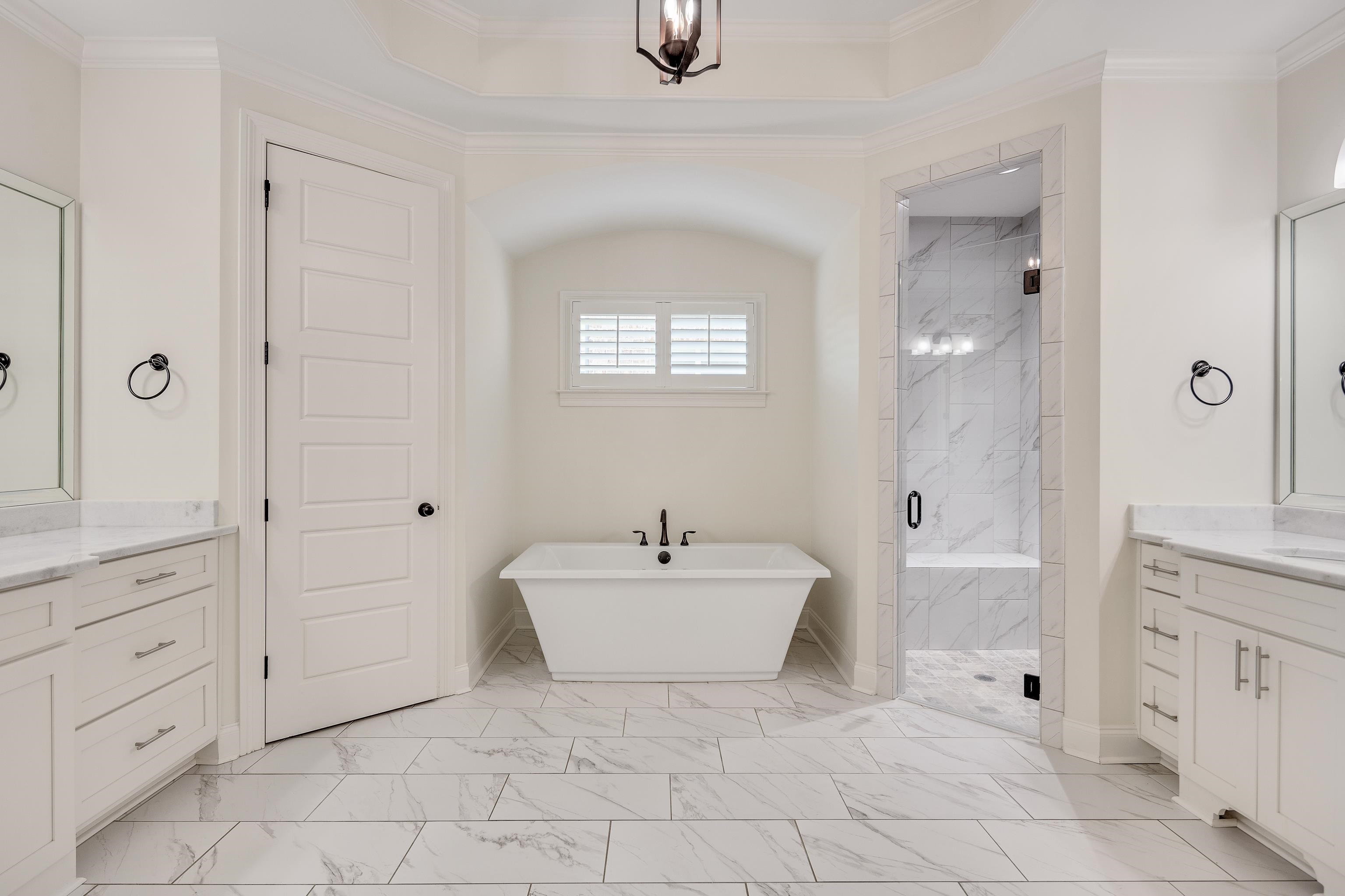 4728 Carousel Lane Collierville, TN 38017 - Photo 18 of 40 Bathroom featuring marble look tiles, a marble finish shower, vanity, a freestanding tub, and ornamental molding