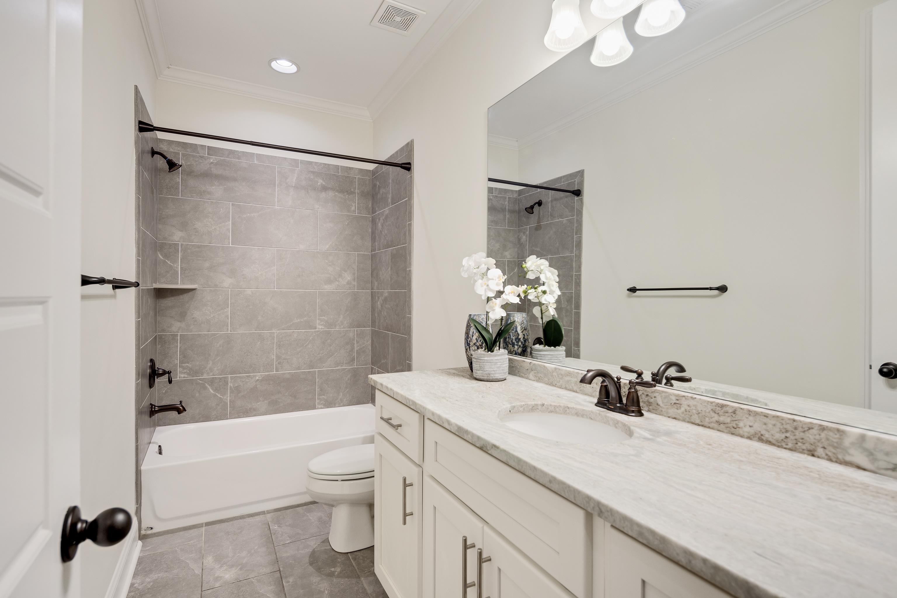 4728 Carousel Lane Collierville, TN 38017 - Photo 23 of 40 Bathroom featuring toilet, vanity, washtub / shower combination, ornamental molding, and tile patterned flooring
