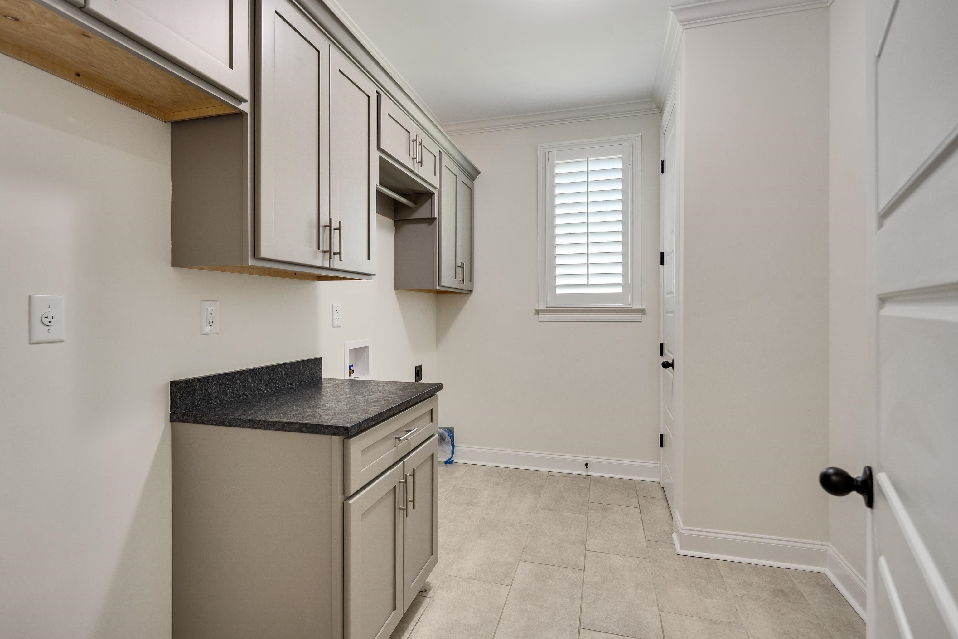 4728 Carousel Lane Collierville, TN 38017 - Photo 24 of 40 Washroom with cabinet space, crown molding, light tile patterned flooring, electric dryer hookup, and baseboards