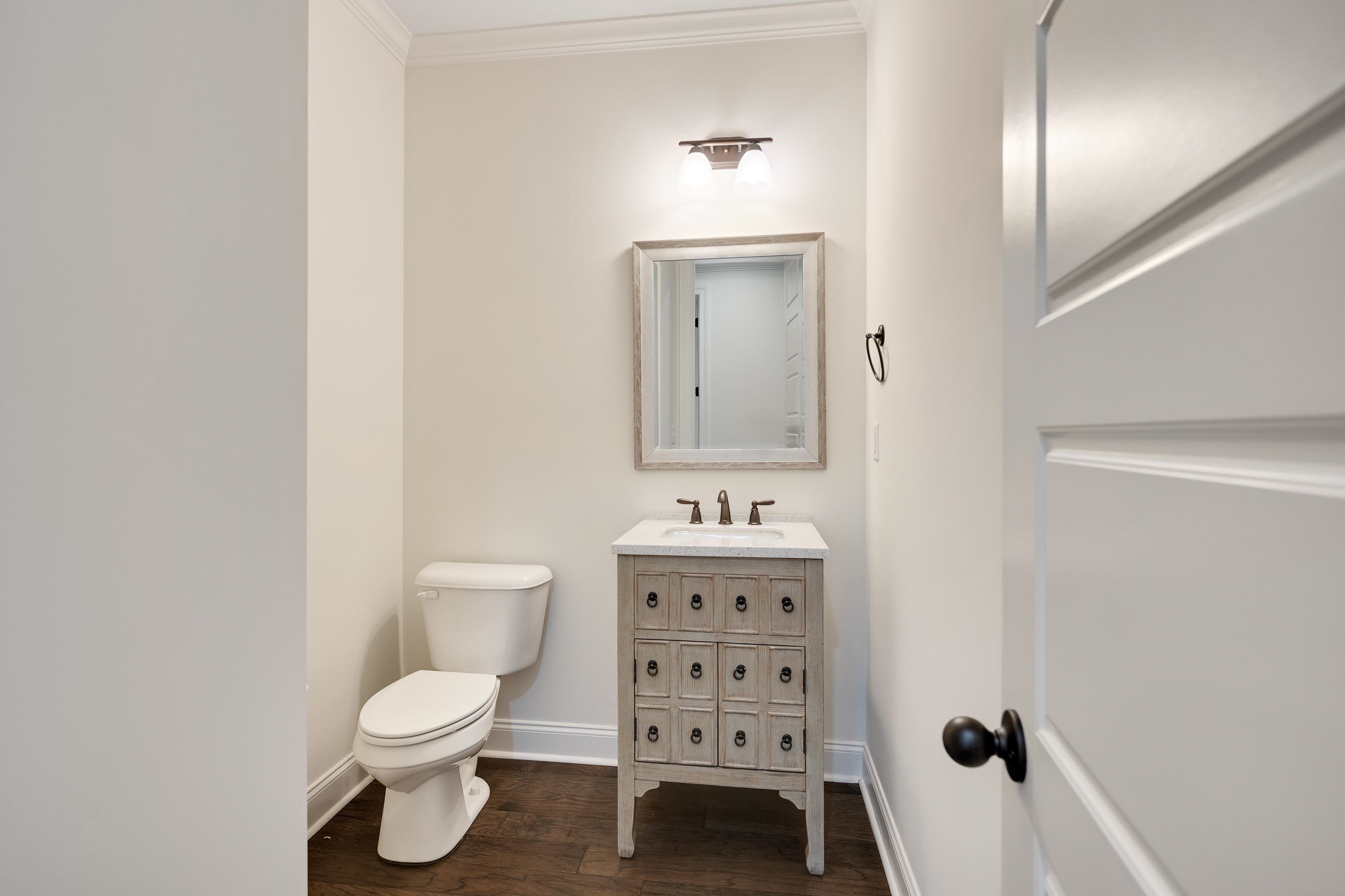 4728 Carousel Lane Collierville, TN 38017 - Photo 27 of 40 Half bathroom with wood finished floors, baseboards, ornamental molding, toilet, and vanity
