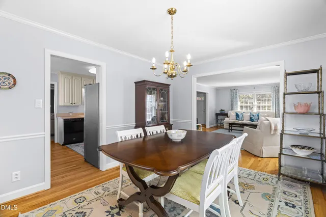 a dining room with furniture wooden floor a rug and a chandelier