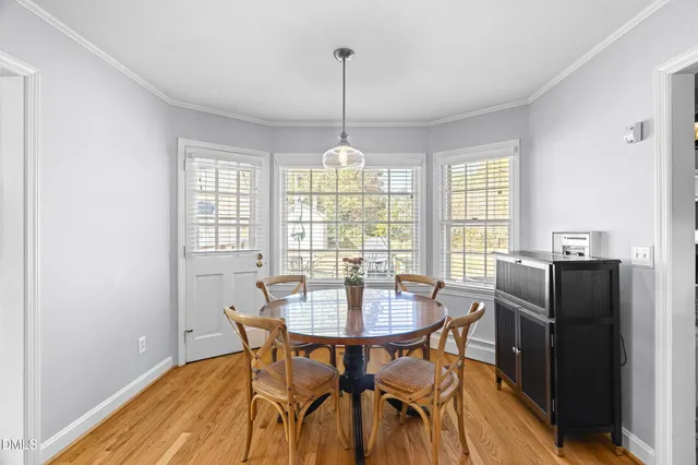 a dining room with furniture a chandelier and wooden floor
