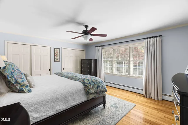 a bedroom with a large bed a chandelier and a window