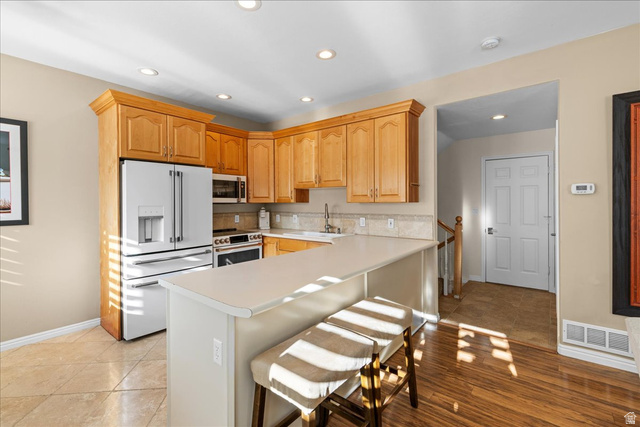 7824 South Sequoia Tree Lane Sandy, UT 84094 - Photo 11 of 43 Kitchen featuring high end white refrigerator, light countertops, stainless steel microwave, electric range oven, and a kitchen breakfast bar