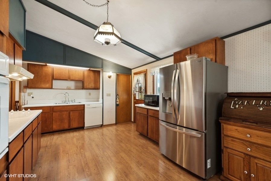 4605 South Ridgeway Road Ringwood, IL 60072 - Photo 8 of 25 a kitchen with stainless steel appliances granite countertop a refrigerator a stove and a sink with wooden floor