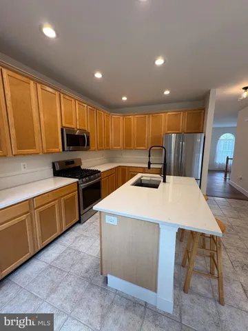a kitchen with stainless steel appliances granite countertop a sink a stove a refrigerator a microwave with island and chairs