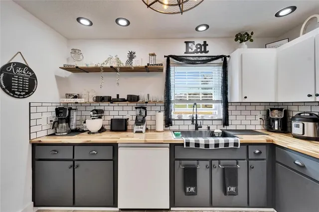 a kitchen with kitchen island granite countertop a sink a stove and cabinets