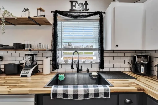 a view of a kitchen with stainless steel appliances granite countertop a sink and cabinets