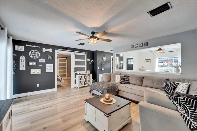 a living room with furniture ceiling fan and a window