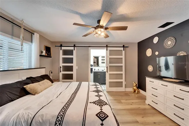 a bedroom with a bed and a flat screen tv