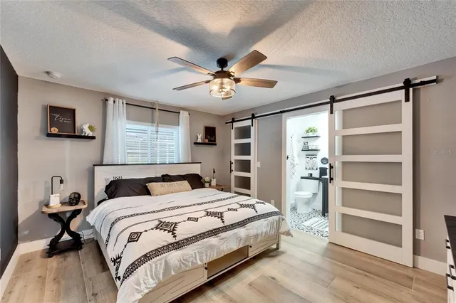 a bedroom with a bed and a ceiling fan