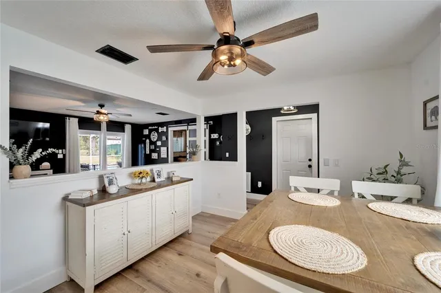 a kitchen with stainless steel appliances granite countertop a sink and chairs