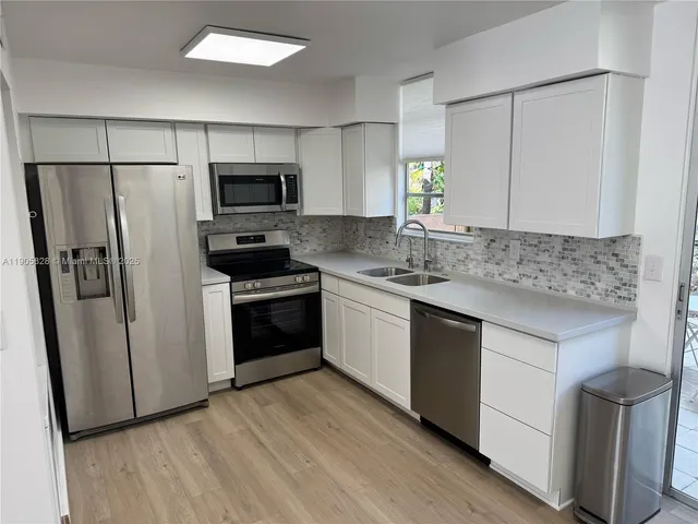 a kitchen with a refrigerator sink and microwave