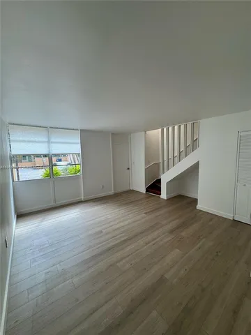 an empty room with wooden floor and door
