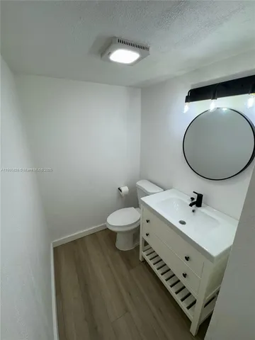 a bathroom with a toilet a sink and mirror
