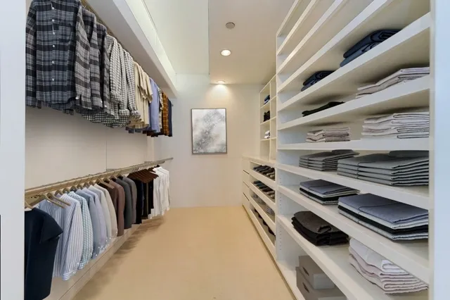 a view of walk in closet with clothes and shoes