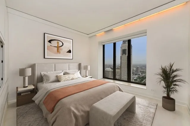 a bedroom with a large bed and a potted plant