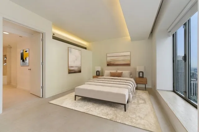 a spacious bedroom with a bed and painting on the wall