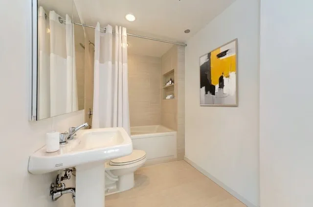a bathroom with a bathtub shower sink and toilet