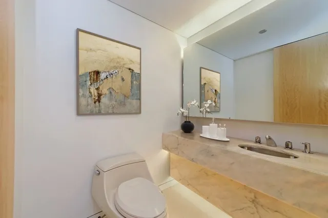 a bathroom with a toilet sink and mirror