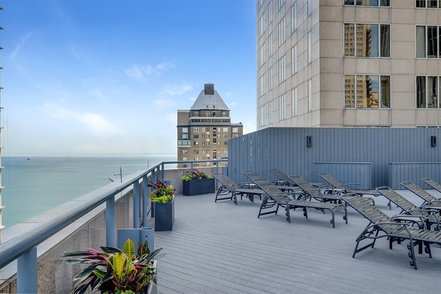 950 North Michigan Avenue, Unit 4003 Chicago, IL 60611 - Photo 24 of 28 a roof deck with table and chairs potted plants with wooden floor