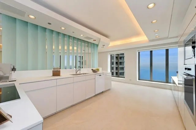 a large white room with a large window and furniture