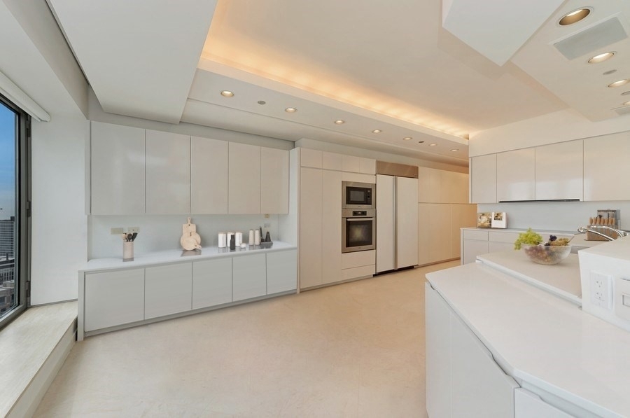 950 North Michigan Avenue, Unit 4003 Chicago, IL 60611 - Photo 5 of 28 a view of a kitchen with refrigerator and white cabinets
