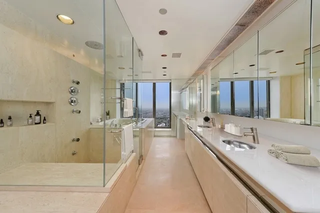 a large bathroom with a double vanity sink toilet mirror and bathtub