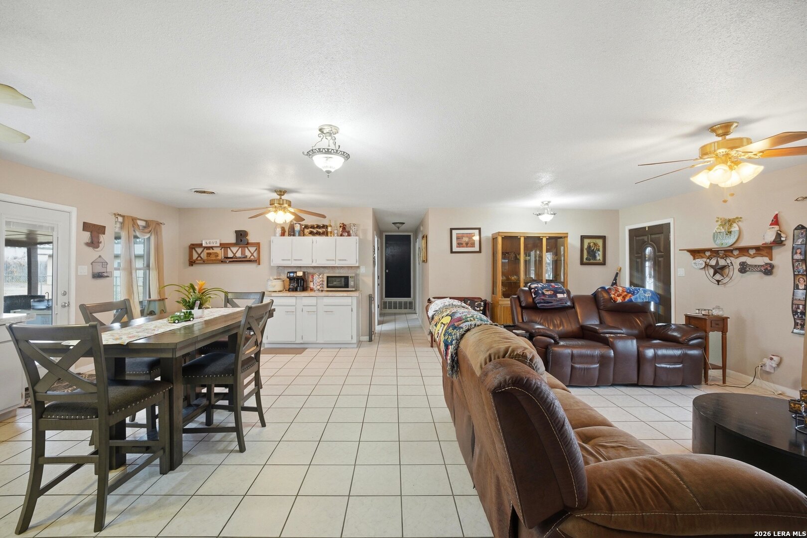 15047 Mesquite Street Lytle, TX 78052 - Photo 17 of 34 a living room with furniture a dining table and chairs with kitchen view