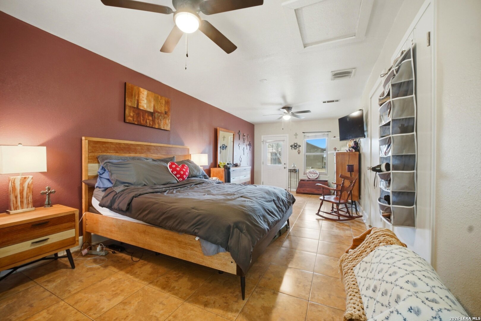 15047 Mesquite Street Lytle, TX 78052 - Photo 30 of 34 a spacious bedroom with a bed a table and potted plant