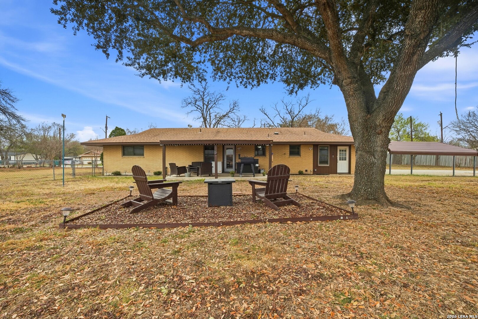 15047 Mesquite Street Lytle, TX 78052 - Photo 32 of 34 a view of a house with backyard and a tree