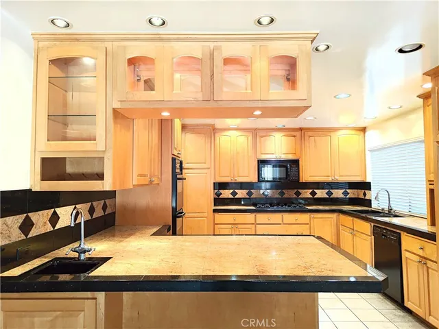 a kitchen with stainless steel appliances granite countertop a sink and a stove