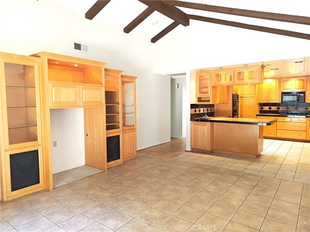 a view of a kitchen with kitchen island a large window cabinets and stainless steel appliances