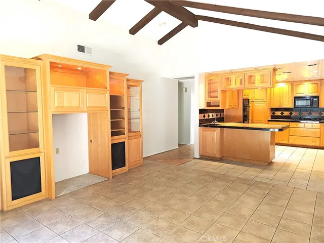 a view of a kitchen with kitchen island a large window cabinets and stainless steel appliances