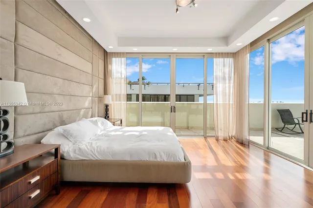 a living room with hardwood floor and large window