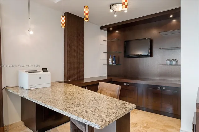 a kitchen with kitchen island a sink stainless steel appliances and a counter top space