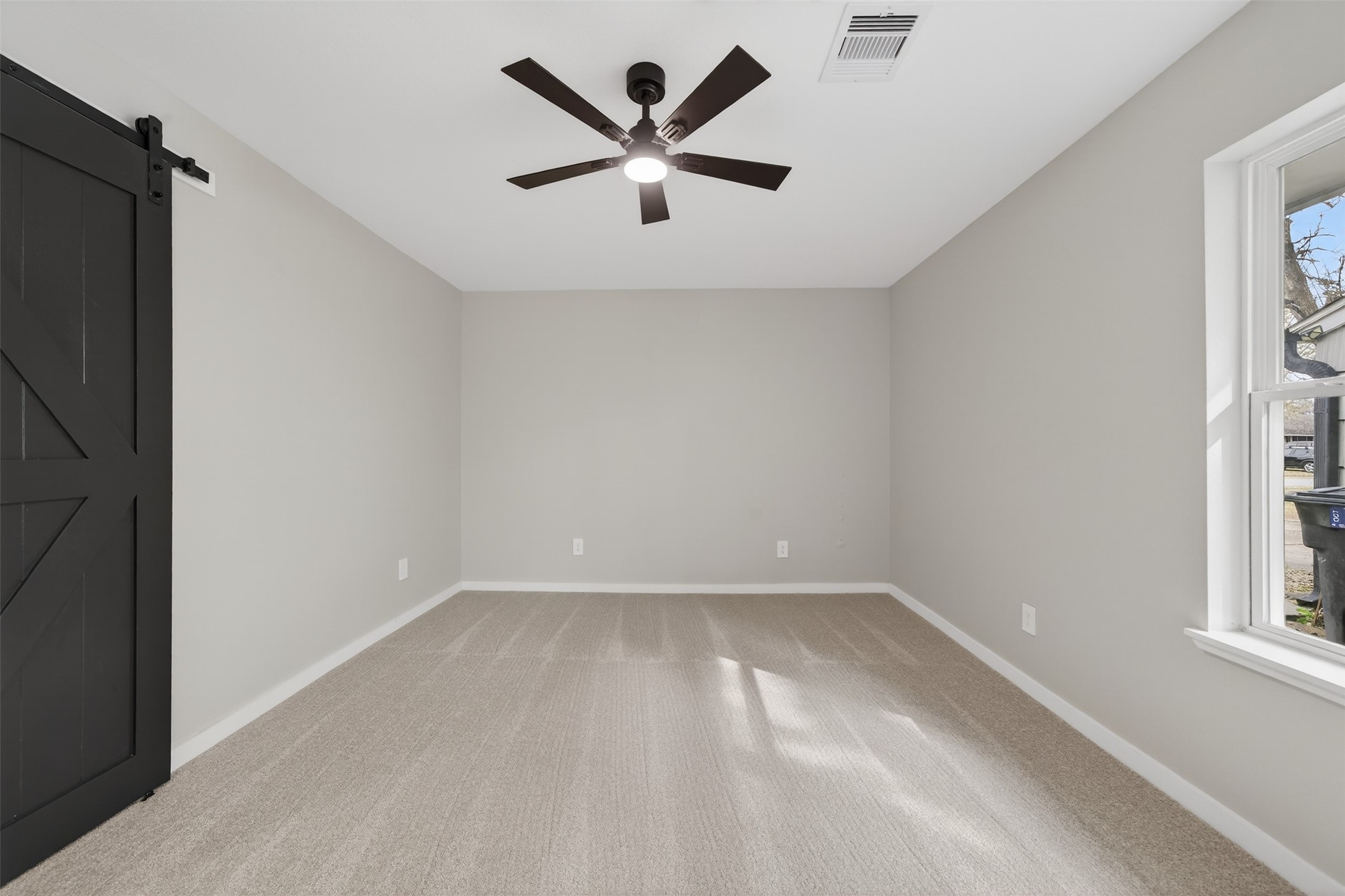6026 Ridgeway Drive Houston, TX 77033 - Photo 19 of 27 an empty room with windows and ceiling fan
