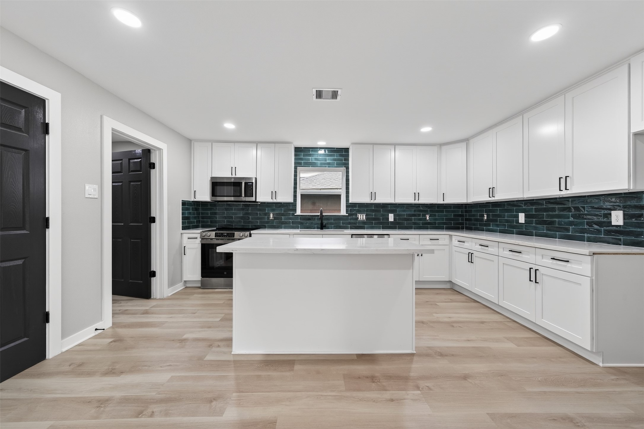 6026 Ridgeway Drive Houston, TX 77033 - Photo 3 of 27 a kitchen with stainless steel appliances granite countertop a stove a sink a refrigerator and white cabinets
