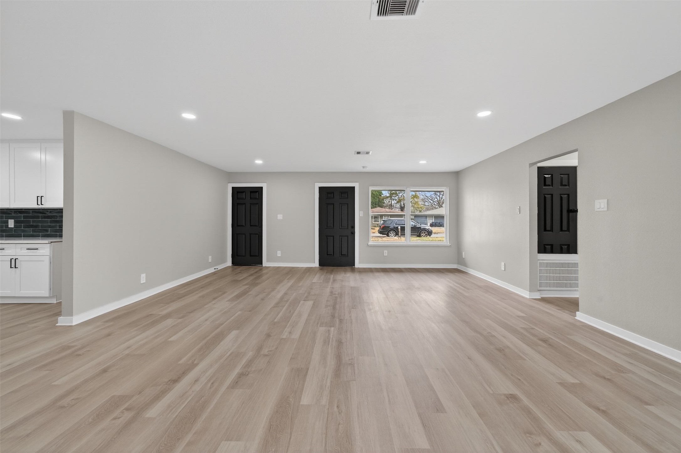 6026 Ridgeway Drive Houston, TX 77033 - Photo 9 of 27 a view of an empty room with a window and wooden floors