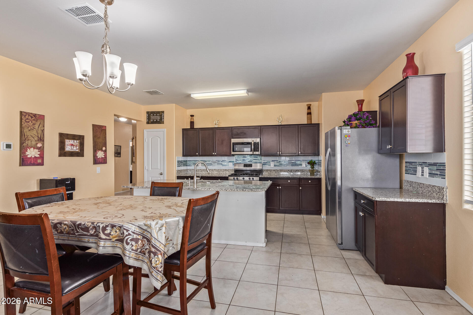 3847 North 308th Lane Buckeye, AZ 85396 - Photo 11 of 32 a kitchen with stainless steel appliances granite countertop a stove a sink a refrigerator and a refrigerator