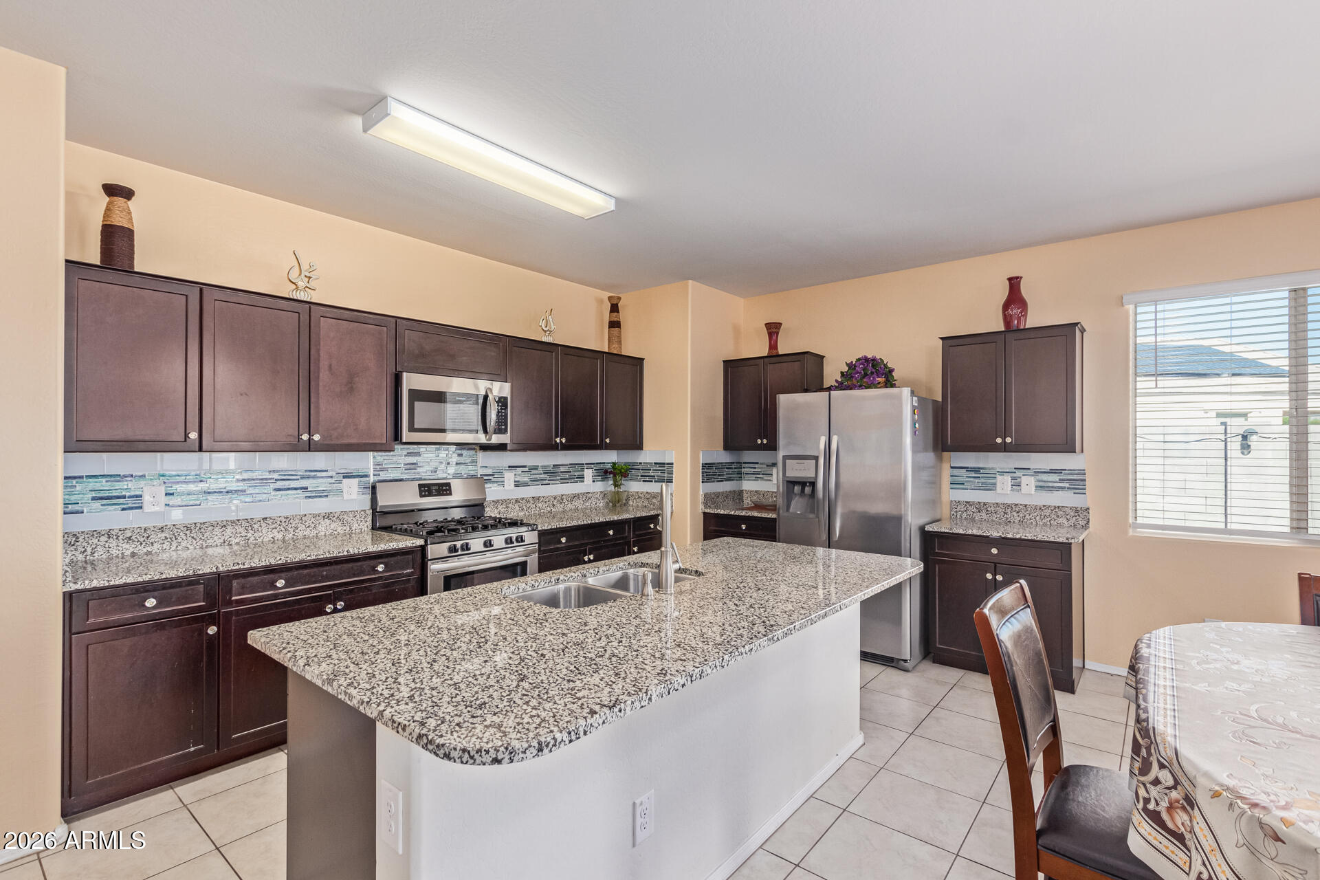 3847 North 308th Lane Buckeye, AZ 85396 - Photo 13 of 32 a kitchen with stainless steel appliances granite countertop a stove refrigerator sink and microwave