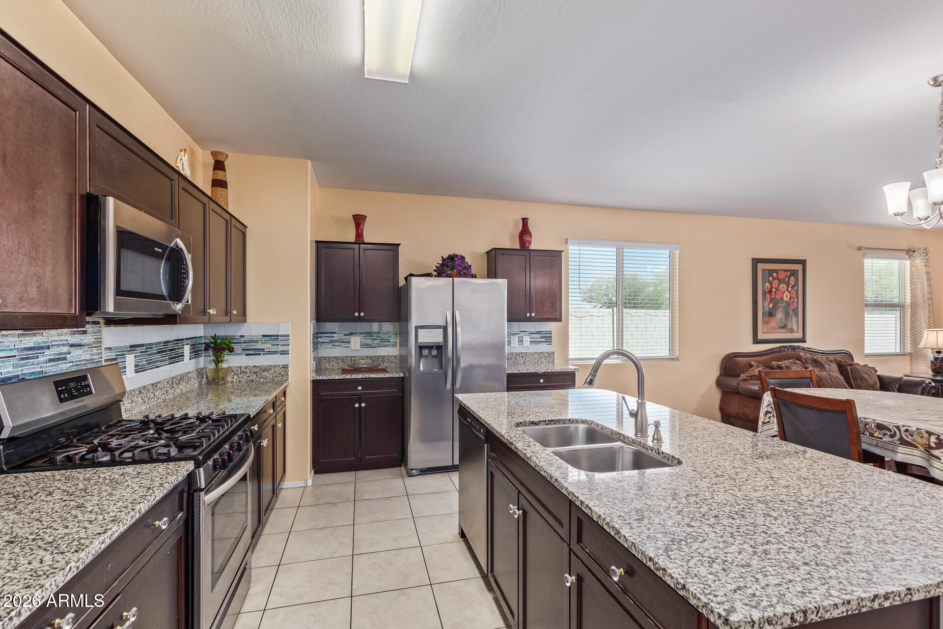 3847 North 308th Lane Buckeye, AZ 85396 - Photo 14 of 32 a kitchen with stainless steel appliances granite countertop a sink stove and refrigerator