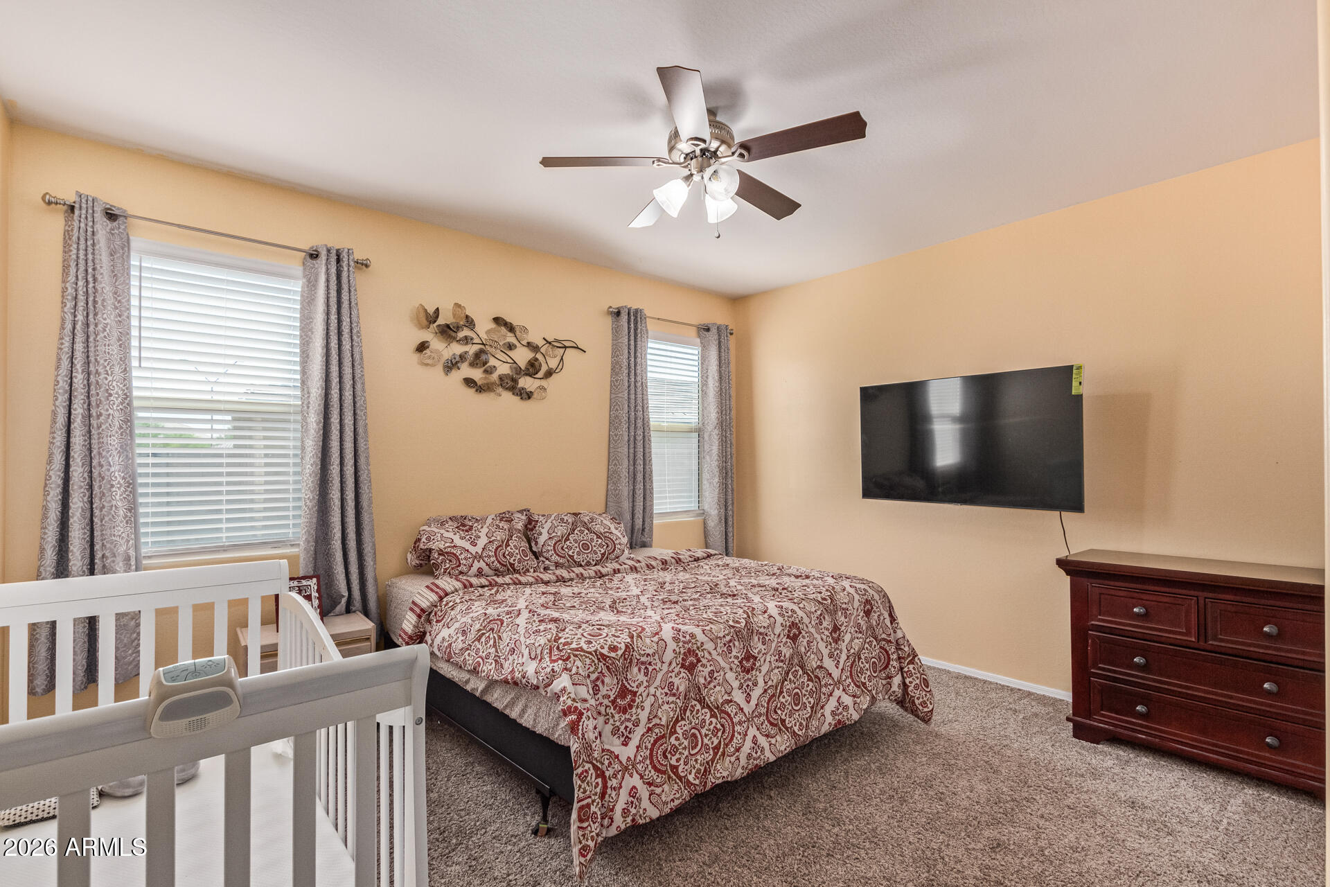 3847 North 308th Lane Buckeye, AZ 85396 - Photo 16 of 32 a bedroom with a bed a flat screen tv and a window
