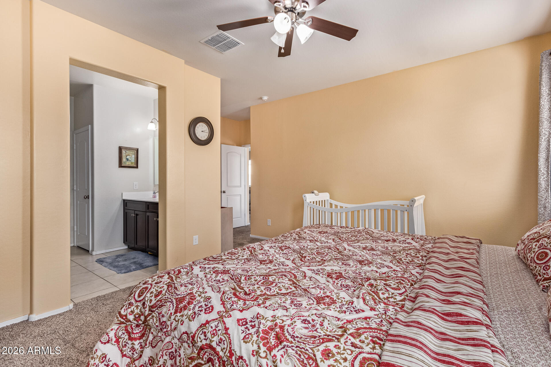 3847 North 308th Lane Buckeye, AZ 85396 - Photo 18 of 32 a bedroom with a large bed and a chandelier